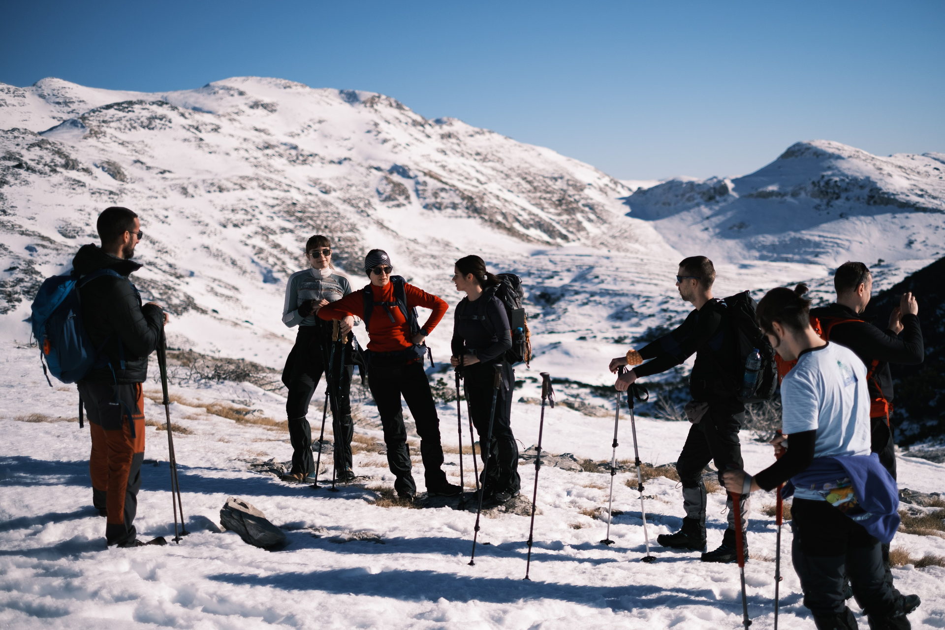 Grupo reunido en briefing sobre la nieve, con cumbres nevadas al fondo